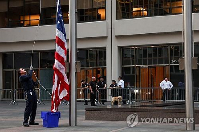 뉴욕 총기 난사 건물 앞에서 조기 게양하는 남성