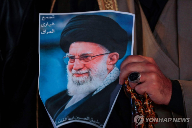 아야톨라 알리 하메네이 사진을 들고 있는 지지자